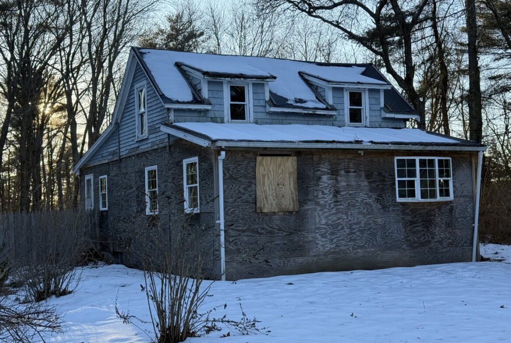 Boarded cape with exposed sheathing in southeastern Massachusetts